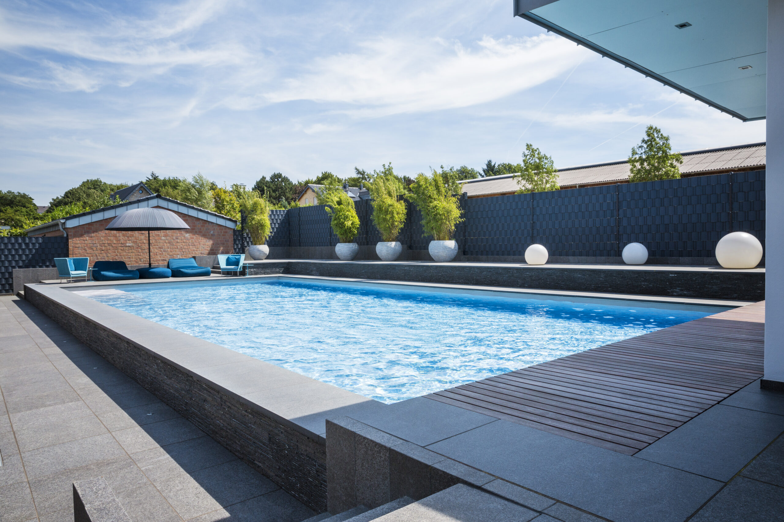 Schwimmbad vor Pavillon und Sitzgelegenheit im Sonnenschein