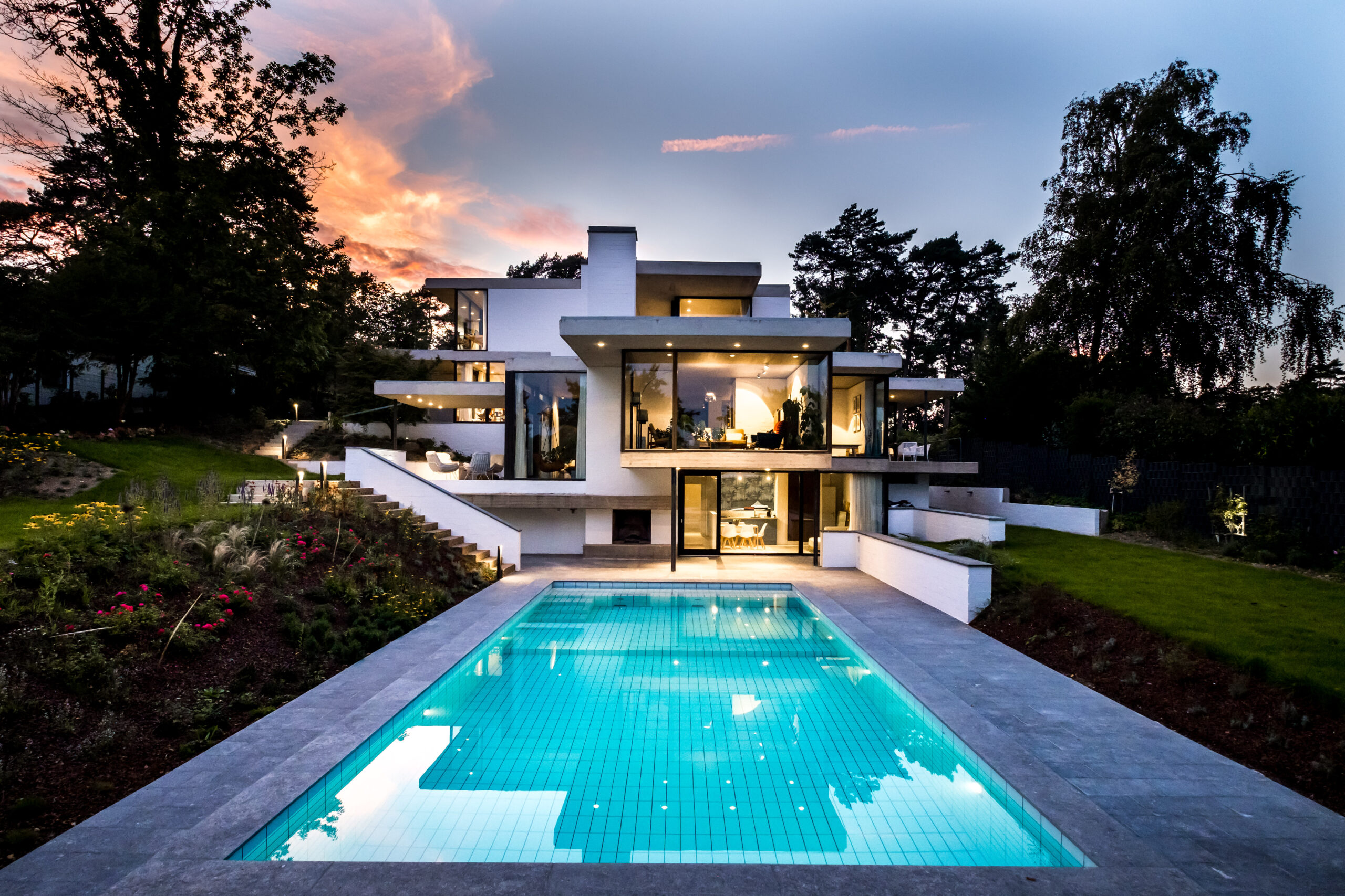 Pool mit modernem Haus im Abendlicht