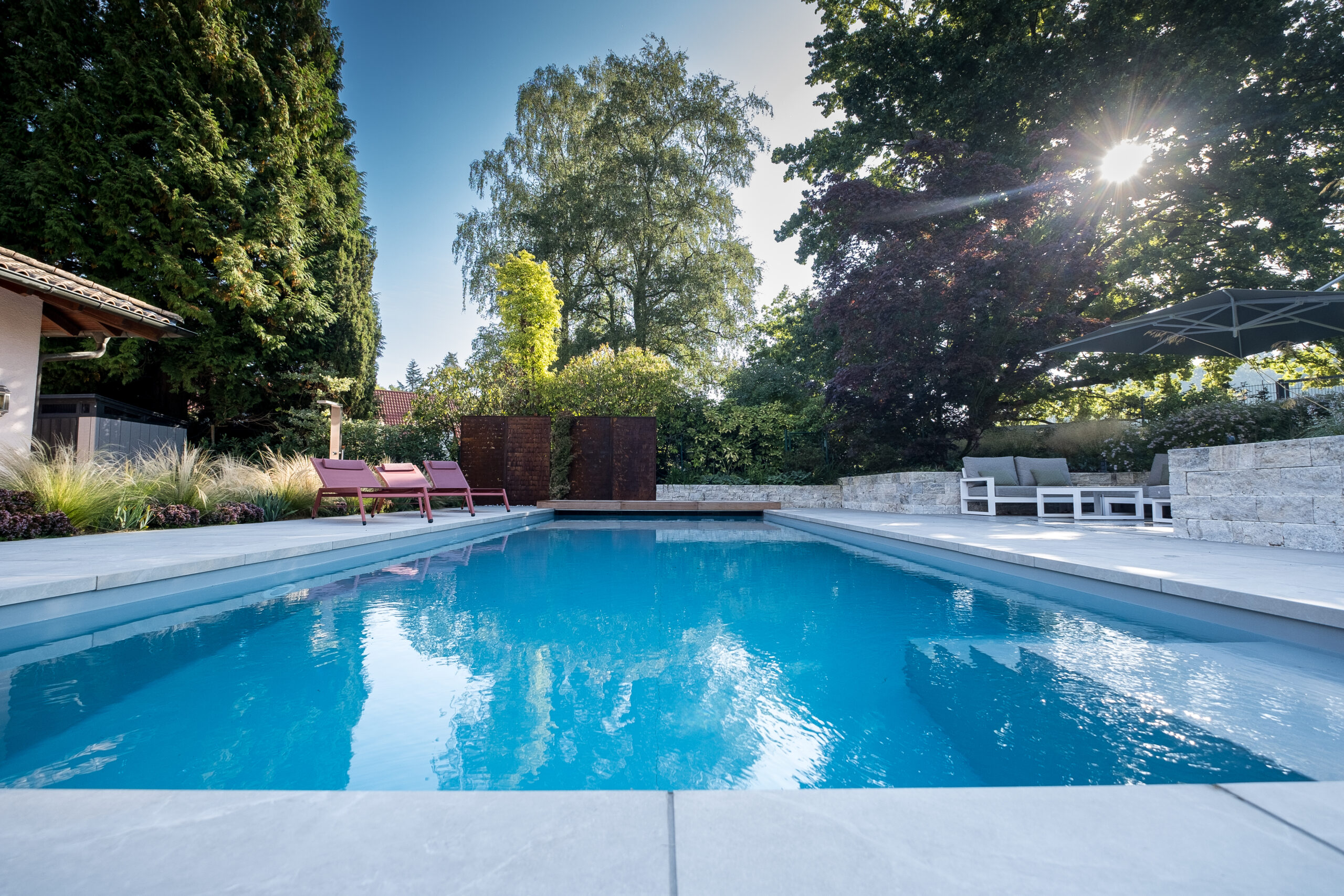 Pool mit rosa Liegen im Garten