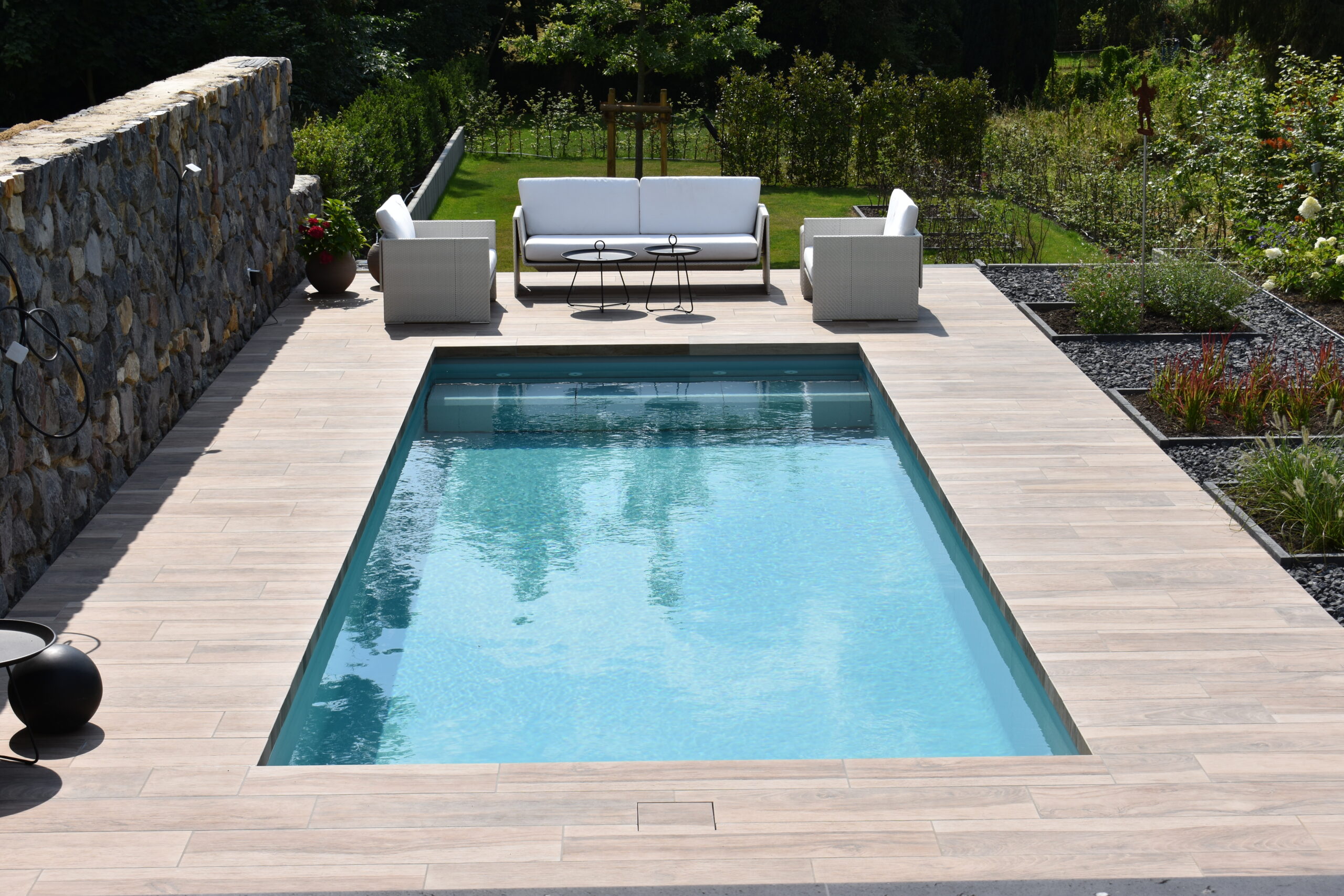 Pool im Garten mit Sitzecke auf Holzboden